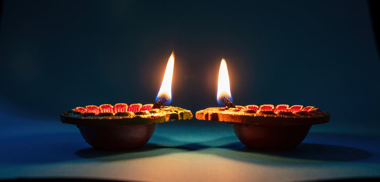 Diwali, Deepavali Hindu festival of lights. Diya lamp lit on blue close up