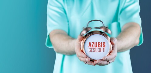 Azubis gesucht!. Doktor zeigt Uhr/Wecker mit Text. Hintergrund blau