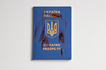Ukraine biometric passport in red blood isolated on the white background, top view. Brave for Ukraine. Symbol of freedom
