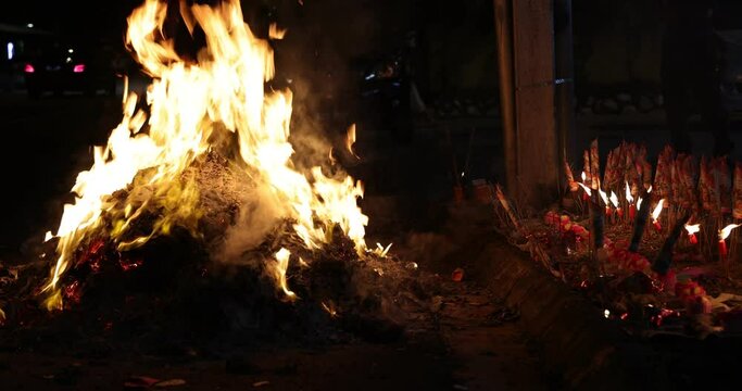 Chinese hungry ghost festival burning flame fire glowing ashes firefly colourful variety prayer paper joss money fake currency joss stick mini fag food fruit