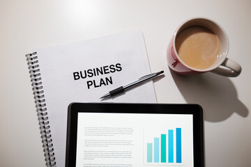 Business plan with touchscreen and coffee.