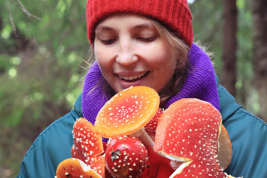 person fly agaric, woman holding fly agaric, dangerous poisonous mushroom, eating herbal medicine