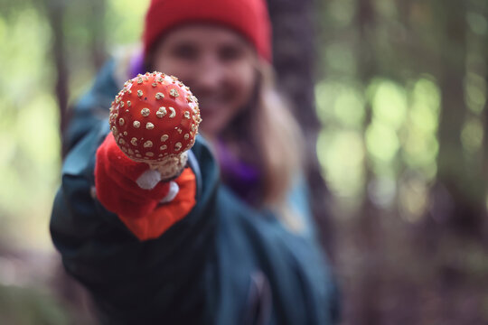 person fly agaric, woman holding fly agaric, dangerous poisonous mushroom, eating herbal medicine