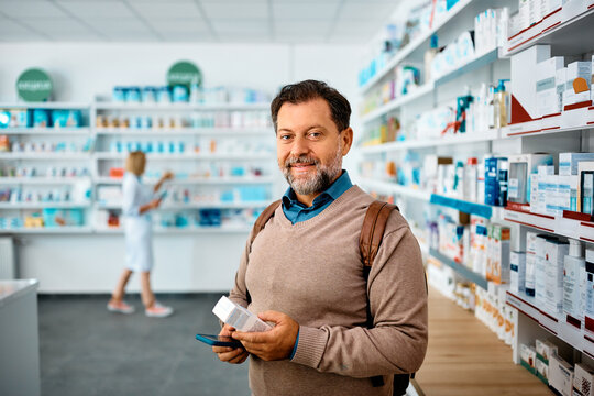 Male customer shopping in pharmacy and looking at camera.