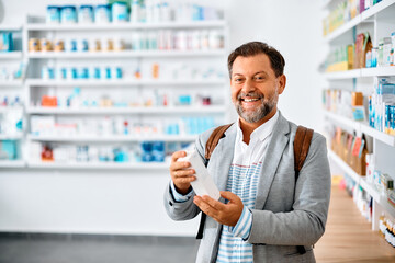 Happy mature man buying medicine in pharmacy.