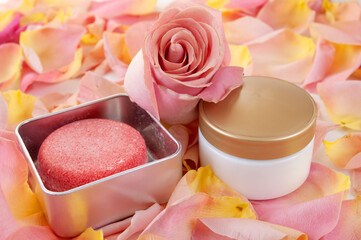 Cream cosmetic in bottle, fresh pink rose flowers and pink silk, natural cosmetic