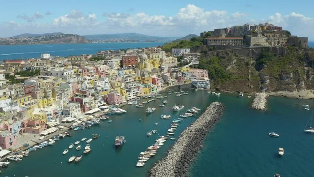 Aerial View of Procida Old Town and Harbour in Gulf of Napoli, Italy. Backwards Drone Shot