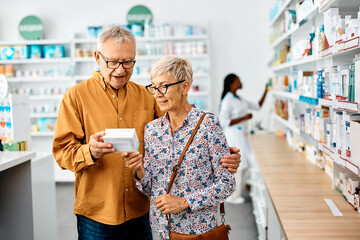 Senior couple read label on medicine package while buying in drugstore.