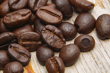 Coffee beans fall on rustic wooden table  Delicious luxury coffee beans and the aroma of morning coffee.