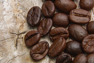 Coffee beans fall on rustic wooden table  Delicious luxury coffee beans and the aroma of morning coffee.