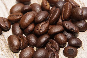 Coffee beans fall on rustic wooden table  Delicious luxury coffee beans and the aroma of morning coffee.