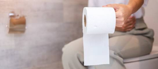 Woman holding toilet paper roll during sit on toilet bowl. diarrhea, constipated period, infection, abdominal, stomachache, cystitis, Insurance and Medical concept
