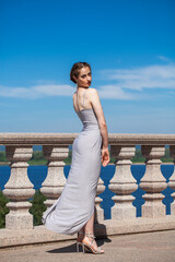 Portrait of a young brunette woman in gray dress