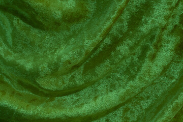 Green velvet fabric surface from above. velvet texture green color background. expensive luxury fabric, material, wallpaper.
