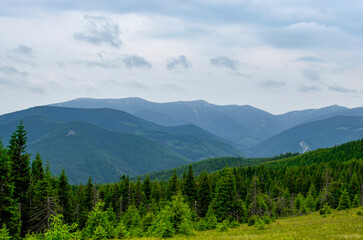 Obraz premium Mountains spring landscape with clouds over the mountains