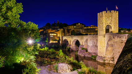 Medieval bridge that crosses the river in the ancient city of Besalu at night, Gerona, Spain.