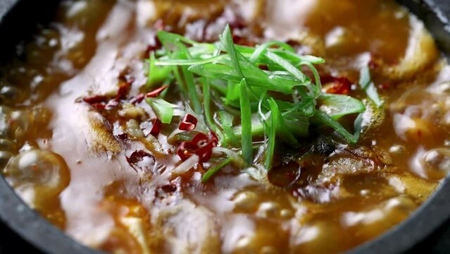 グツグツと煮え立ち湯気が上がる豆腐の、熱々で弾力ある質感を閉じ込めた「麻婆豆腐動画」。濃厚な旨みの輝きと辛味が際立つ一景で、中華料理や石焼メニューの販促に最適な高品質素材です。 | Sizzling hot Mapo Tofu boiling in a stone pot with steam rising.