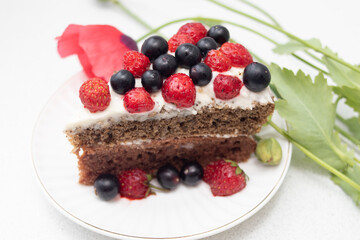 A piece of Cake with red berries on a plate and Pink poppy flower
