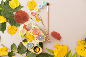 Children's picture made from autumn leaves with pencil drawing on paper