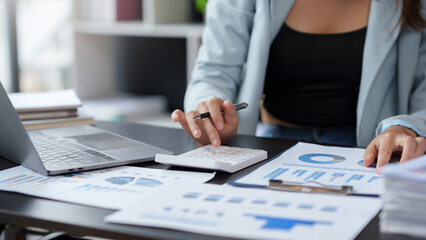 Auditor is examining the financial statement documents using a calculator calculate monthly...