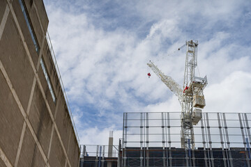 Looking up at a station construction crane with protective scaffolding surrounding its base