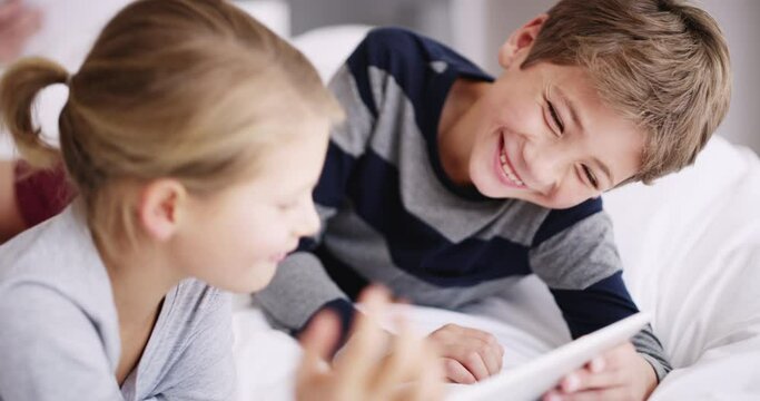 Children with a tablet for online game or digital learning education together on the bed while on holiday or vacation. Happy boy, girl or young people looking at funny meme content on a kid website