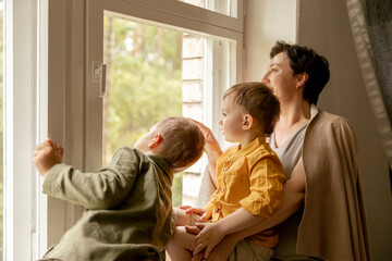 Happy grandmother and her grandsons enjoy time together. Positive middle age woman spending time...