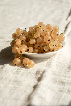 Close-up of fresh white currants in small bowl, white background