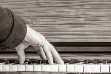 male musician hand playing on piano keys. music background