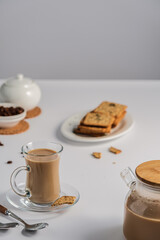 a cup of coffee with milk on a light background, a light breakfast for children, healthy and healthy food, coffee and dry biscuits, bran cracker, top view with copy space	