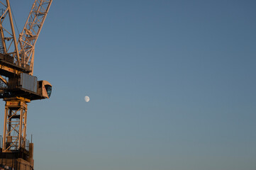 moon over crane on a construction site
