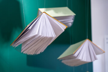 Flying books on dark green background with shadows