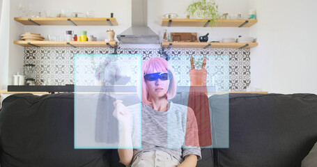 Girl chooses dresses. Puts on 3D glasses, hologram of clothes appears in front of face. Woman's hand swipes the goods in space. VFX concept of online shopping of the future. Front view, indoors.