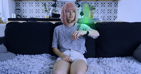 Young girl answers holographic video call of the future with man. Smart watch projecting semi-transparent screen into space. Living room, indoors, medium shot.