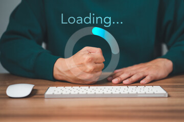 Man using a computer keyboard to download and waiting to loading digital business data form website, concept of waiting for load of loading bar. - obrazy, fototapety, plakaty