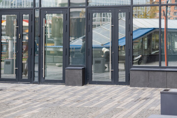 The front door of a office block, reflecting buildings in the glass