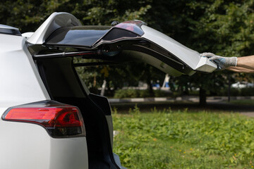Man in gloves closes car trunk door (Corrected)