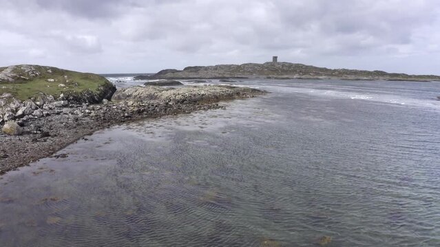 Aerial view of low tide seascape. Beautiful Drone point of view fly of irish coast line at low tide, in the background lighthouse, calm sea in a cloudy day.