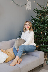 Happy young woman celebrates Christmas alone and is happy alone with herself