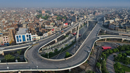 A closeup and an aerial image of Aazadi Chowk's famous interchange and flyover, with its populated neighborhoods in the background.