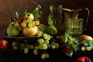 Still life with white wine, apples, pears, grapes and dogwood on a brown background