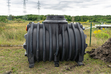 Installation of a single-chamber home sewage treatment plant, the tank is on the lawn. - obrazy, fototapety, plakaty