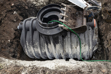 Installation of a single-chamber home sewage treatment plant, the excavator presses the tank.