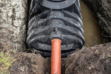 A sewer pipe with a diameter of 160 mm enters the septic tank tank, installation of a...