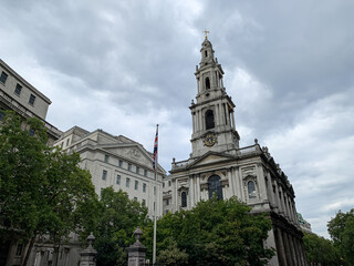 Fototapeta na wymiar London, UK. St Clement Danes Church. Sir Christopher Wren-designed CofE church, on a Strand traffic island. A street view of St Clement Anglican church on the Strand.Cloudy day in capital