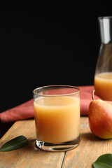 Fresh pear juice in glass and fruit on wooden table
