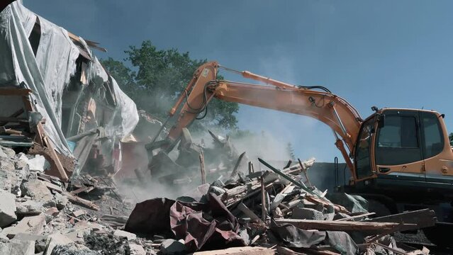 Demolition of building. Excavator breaks old house.
