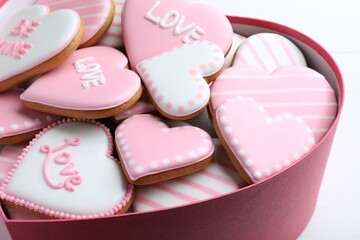 Fototapeta na wymiar Delicious heart shaped cookies in box on white table, closeup. Valentine's Day