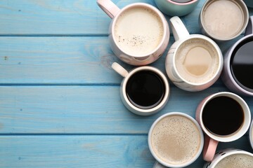 Obraz na płótnie Canvas Many cups of different coffee drinks on light blue wooden table, flat lay. Space for text