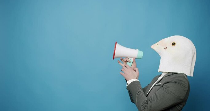 Man with pigeon mask making funny gestures. Man with Pigeon Mask. Fun and happiness concept. Man having fun on isolated Blue Background. Party Halloween. April 1, Fool's Day. Masquarade idea.
